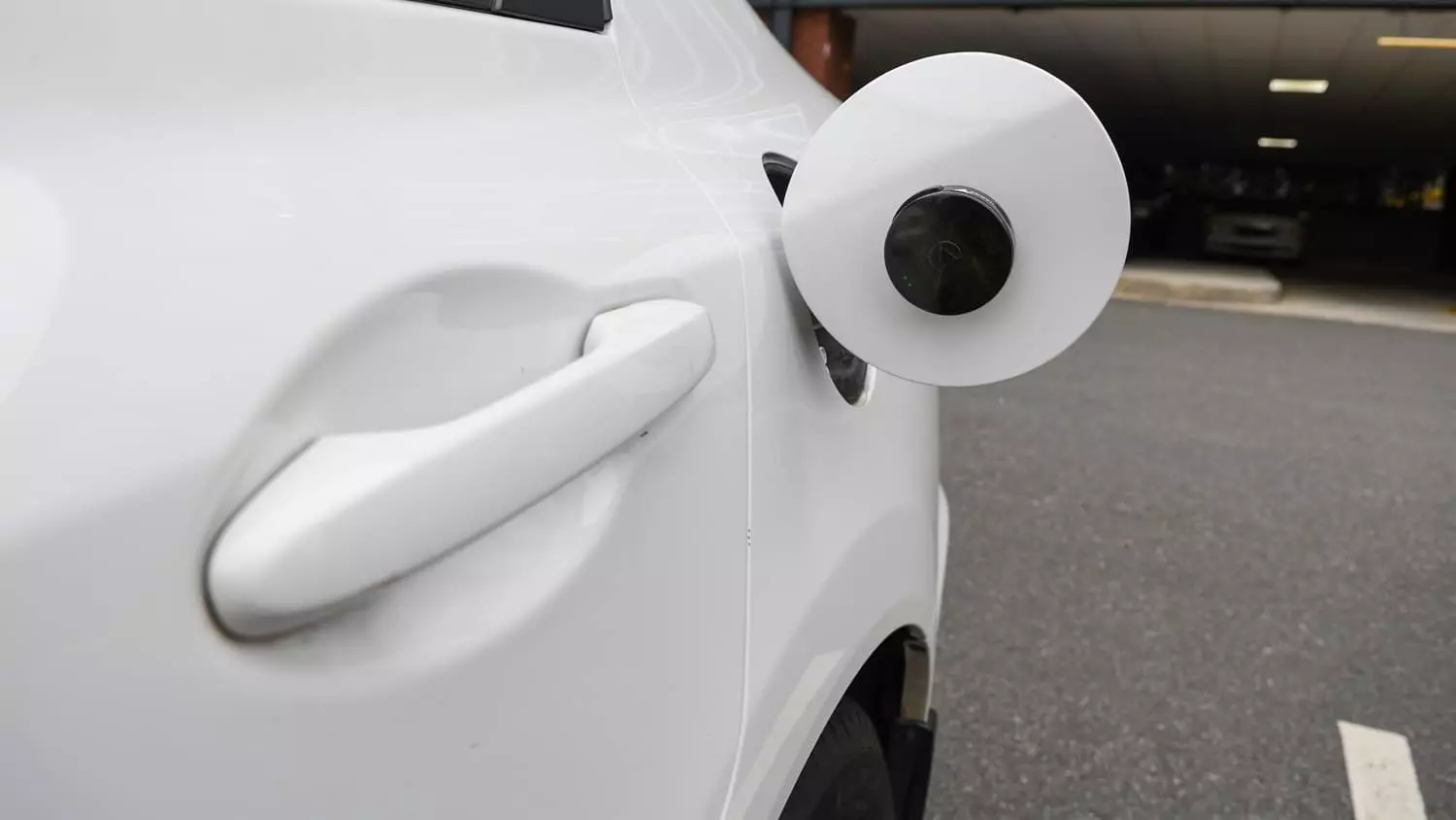 The LandAirSea 54 GPS Tracker installed on the exterior gas cap of a vehicle.