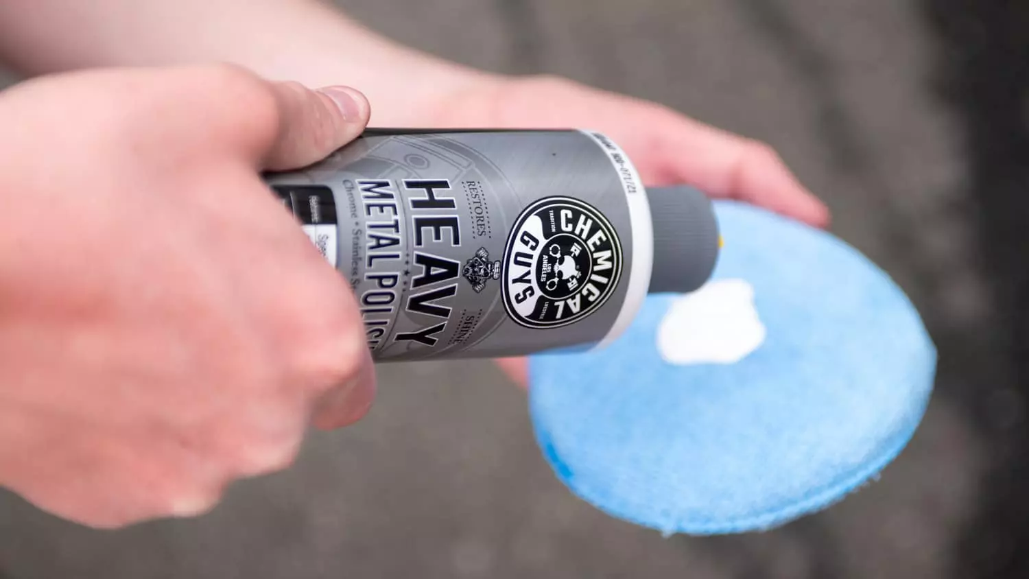 The Chemical Guys Polish being used to clean a vehicle's wheel.