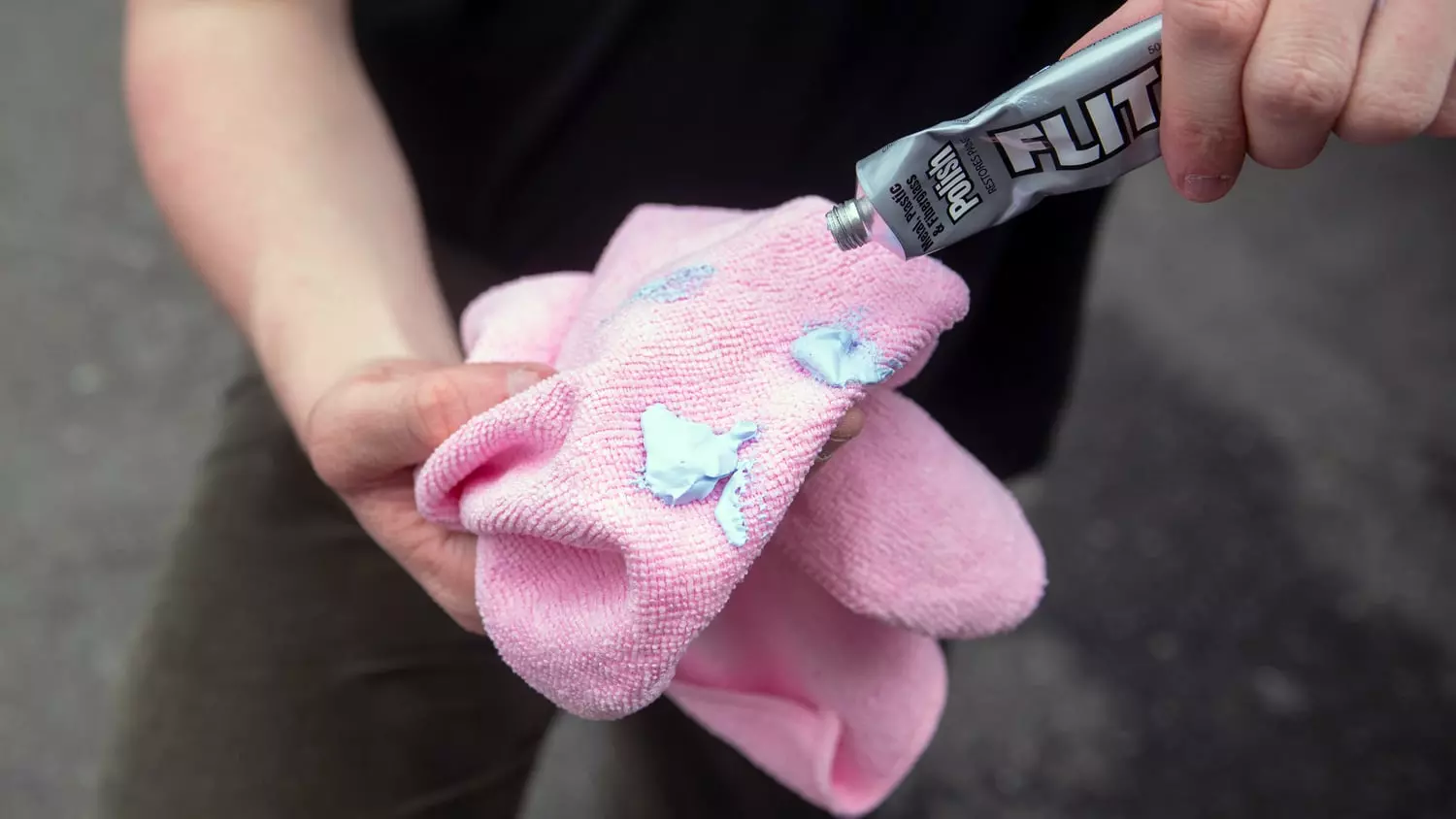 The Flitz Polish being used to clean a vehicle's wheel.
