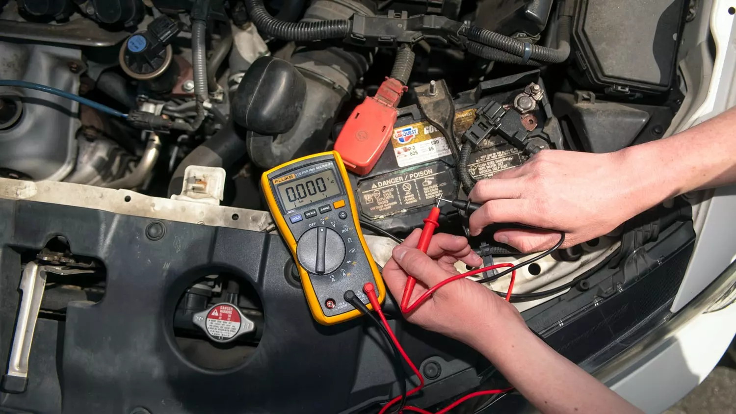 The Fluke 115 Digital Multimeter being used to measure voltage, current, and other electric components in a vehicle.
